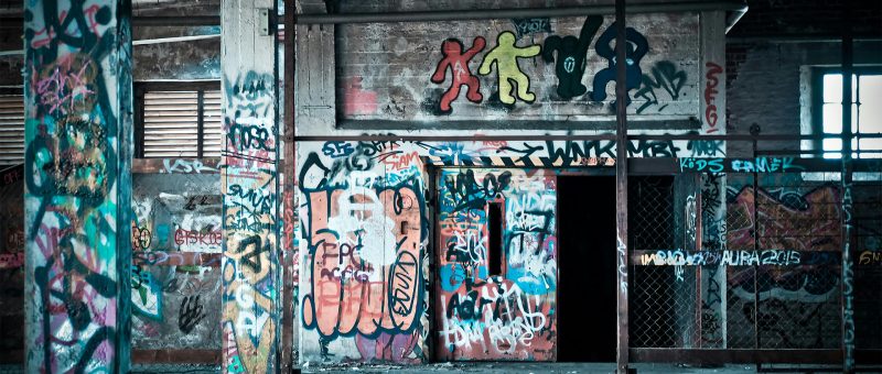 Image of graffiti on walls of industrial building tainting the professional look